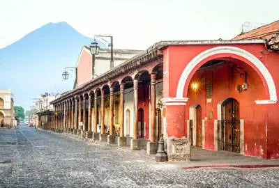 Vista de una calle de Guatemala con volcán al fondo